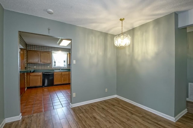42 Hennessey Ct, River Ridge, LA 70123 - kitchen featuring black dishwasher, a chandelier, dark wood-type flooring, dark countertops, and a textured ceiling