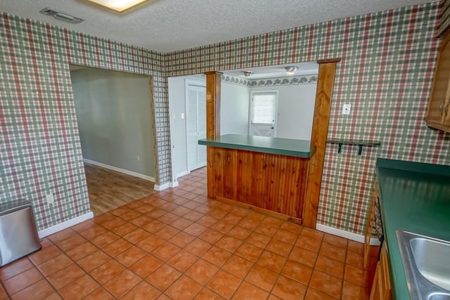 42 Hennessey Ct, River Ridge, LA 70123 - kitchen featuring wallpapered walls, a textured ceiling, and tile patterned floors