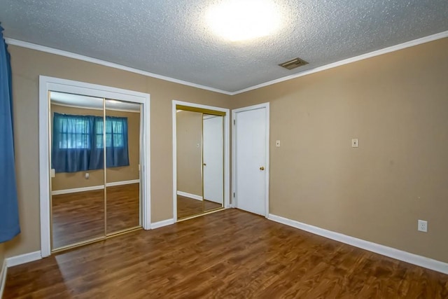 42 Hennessey Ct, River Ridge, LA 70123 - unfurnished bedroom with two closets, a textured ceiling, wood finished floors, and ornamental molding