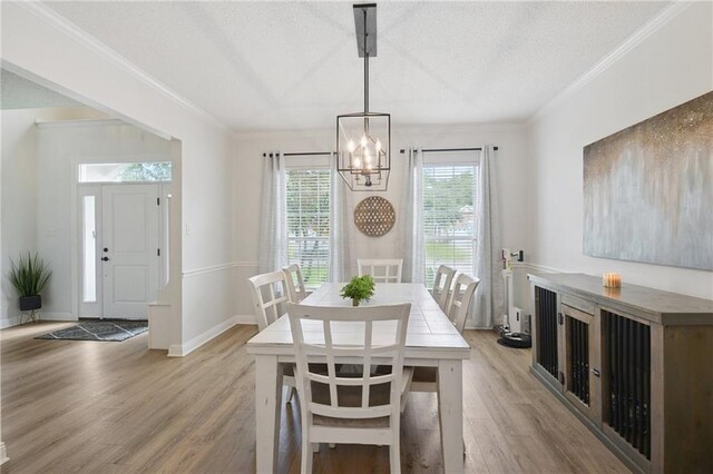 1125 Lori Dr, Slidell, LA 70461 - dining space featuring a chandelier, light wood-style floors, crown molding, and a textured ceiling
