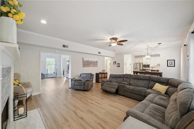 1125 Lori Dr, Slidell, LA 70461 - living area with light wood-style flooring, ceiling fan, recessed lighting, crown molding, and a premium fireplace