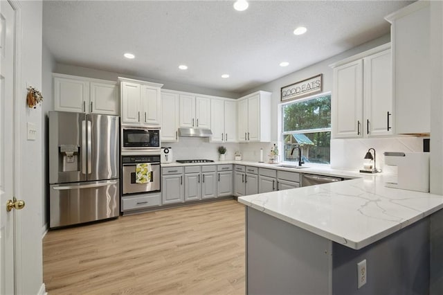 1125 Lori Dr, Slidell, LA 70461 - kitchen featuring black appliances, light wood finished floors, recessed lighting, under cabinet range hood, and tasteful backsplash