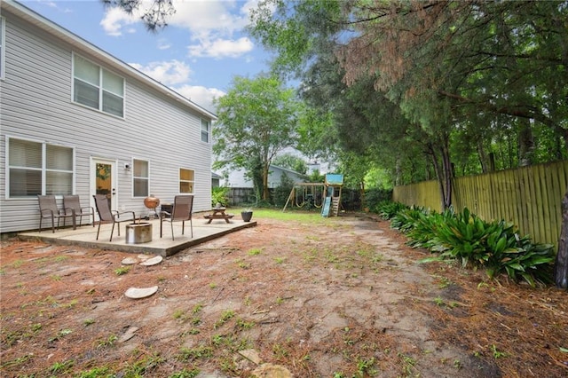 1125 Lori Dr, Slidell, LA 70461 - fenced backyard featuring a playground, a patio area, and an outdoor fire pit