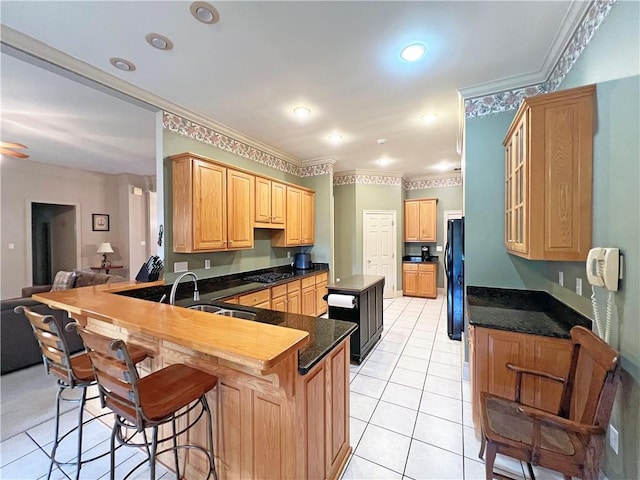 207 Hidden Springs Ln, Covington, LA 70433 - kitchen with light tile patterned floors, a peninsula, crown molding, a breakfast bar area, and glass insert cabinets
