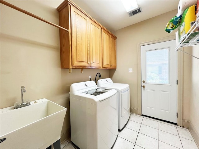 207 Hidden Springs Ln, Covington, LA 70433 - laundry area with washing machine and dryer, cabinet space, and light tile patterned floors