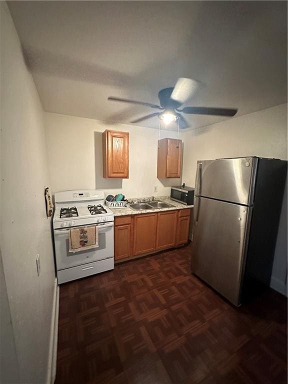 2620-22 Philip St, New Orleans, LA 70113 - kitchen with stainless steel appliances, ceiling fan, light countertops, and brown cabinetry