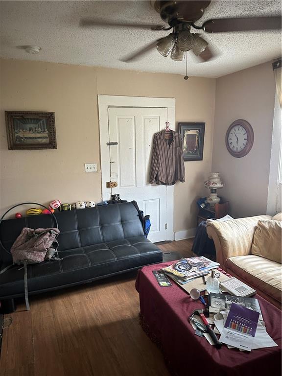 2217 Willow St, New Orleans, LA 70113 - living room featuring wood finished floors, a ceiling fan, and a textured ceiling