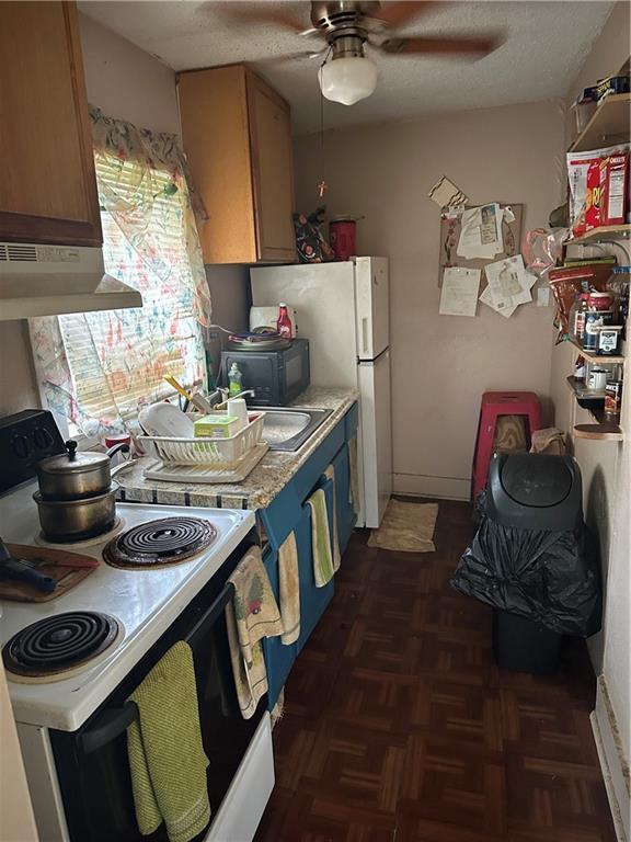 2217 Willow St, New Orleans, LA 70113 - kitchen with electric range, under cabinet range hood, ceiling fan, light countertops, and freestanding refrigerator