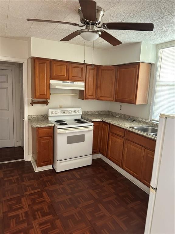 2217 Willow St, New Orleans, LA 70113 - kitchen featuring white appliances, brown cabinets, under cabinet range hood, and ceiling fan