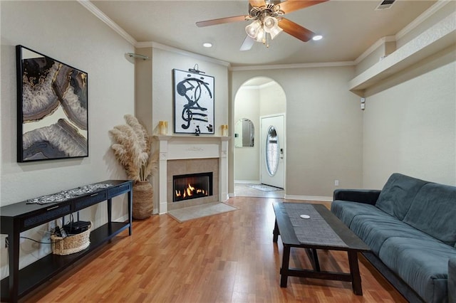 2523 Robin St, Slidell, LA 70460 - living area with ornamental molding, ceiling fan, wood finished floors, a fireplace, and arched walkways