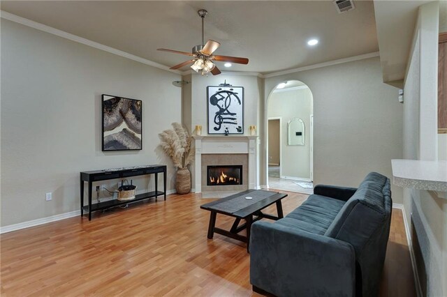 2523 Robin St, Slidell, LA 70460 - living room featuring a ceiling fan, ornamental molding, a tiled fireplace, arched walkways, and recessed lighting