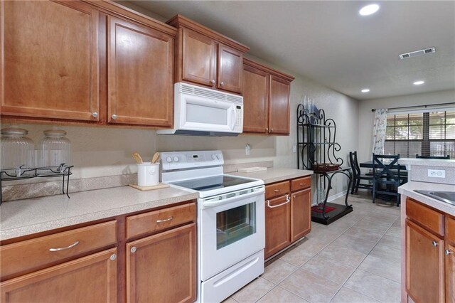 2523 Robin St, Slidell, LA 70460 - kitchen featuring white appliances, light tile patterned flooring, recessed lighting, and brown cabinetry