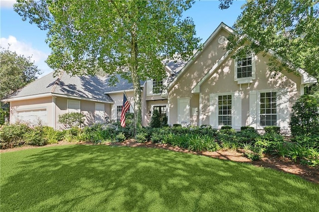104 Acadian Ln, Mandeville, LA 70471 - view of front facade with a front lawn, stucco siding, and a garage