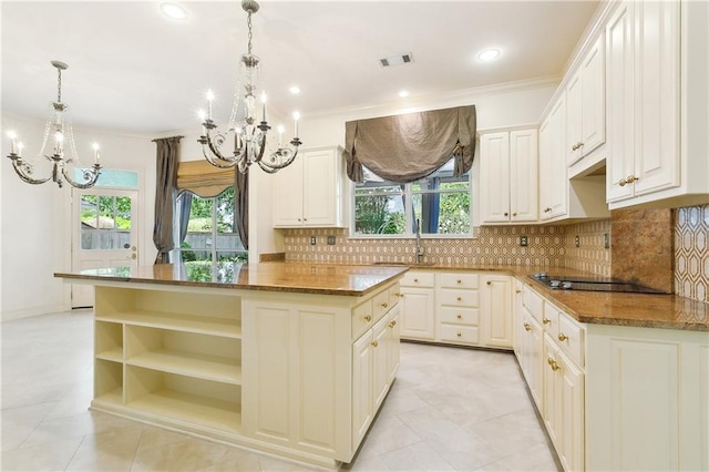 104 Acadian Ln, Mandeville, LA 70471 - kitchen with a chandelier, a kitchen island, black electric stovetop, plenty of natural light, and ornamental molding
