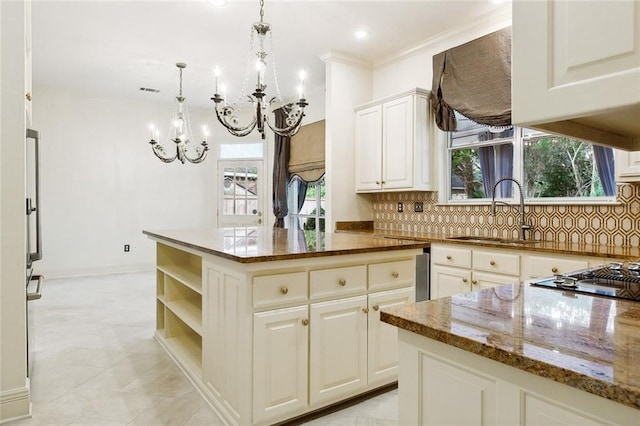 104 Acadian Ln, Mandeville, LA 70471 - kitchen with a chandelier, dark stone counters, tasteful backsplash, white cabinets, and decorative light fixtures