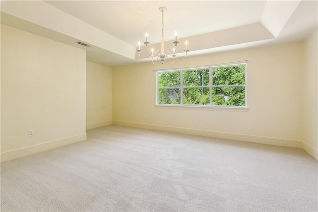 104 Acadian Ln, Mandeville, LA 70471 - spare room featuring a tray ceiling, a chandelier, and light colored carpet
