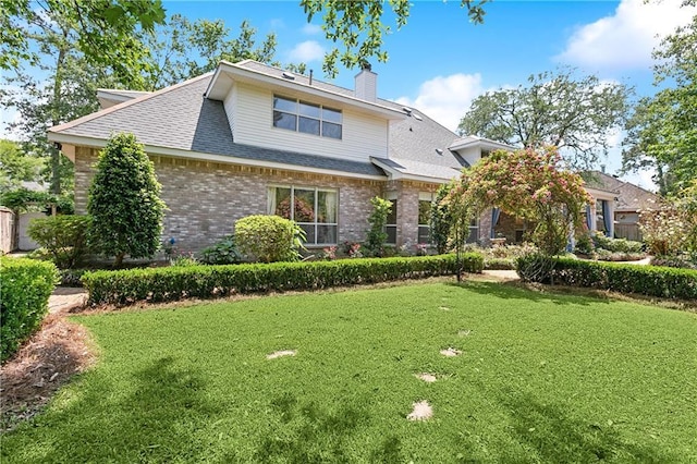 104 Acadian Ln, Mandeville, LA 70471 - view of front of property with a chimney, a front yard, brick siding, and roof with shingles
