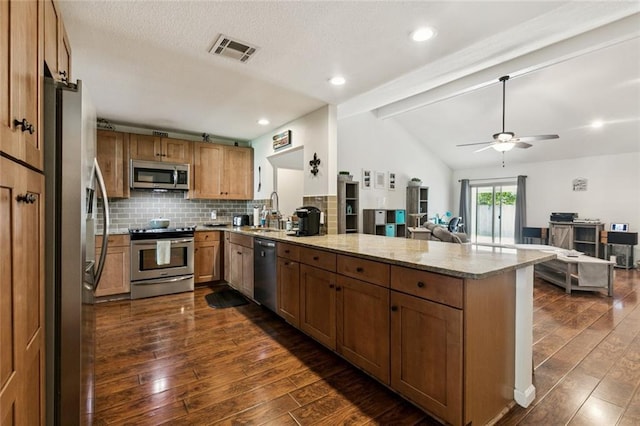 124 Brentwood Dr, Belle Chasse, LA 70037 - kitchen featuring appliances with stainless steel finishes, a peninsula, open floor plan, dark wood-style flooring, and a ceiling fan