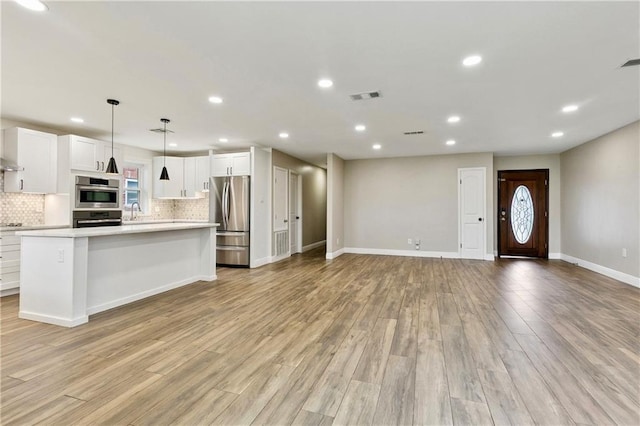 1424 Pecan Ave, Metairie, LA 70001 - kitchen featuring appliances with stainless steel finishes, light countertops, open floor plan, backsplash, and recessed lighting