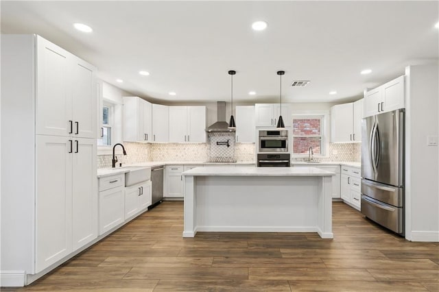 1424 Pecan Ave, Metairie, LA 70001 - kitchen with appliances with stainless steel finishes, wall chimney range hood, light countertops, decorative backsplash, and recessed lighting