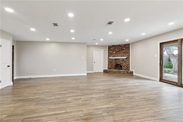 1424 Pecan Ave, Metairie, LA 70001 - unfurnished living room with light wood finished floors, recessed lighting, and a brick fireplace