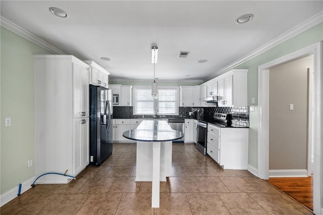 900 S Cypress St, Hammond, LA 70403 - kitchen featuring stainless steel appliances, backsplash, a kitchen island, under cabinet range hood, and ornamental molding