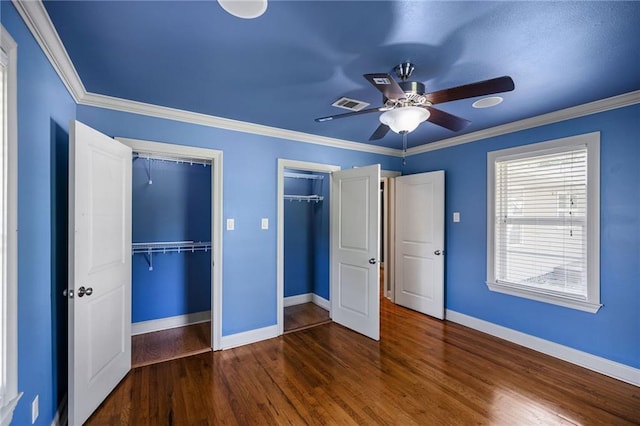 900 S Cypress St, Hammond, LA 70403 - unfurnished bedroom featuring wood finished floors, two closets, ornamental molding, and a ceiling fan