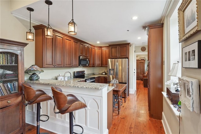 1225 Bourbon St Unit F, New Orleans, LA 70116 - kitchen featuring appliances with stainless steel finishes, a peninsula, light wood-type flooring, a breakfast bar, and recessed lighting
