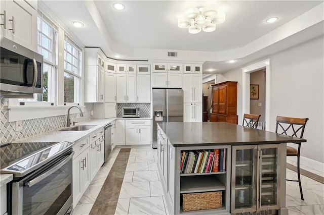 5024 S Claiborne Ave, New Orleans, LA 70125 - kitchen with appliances with stainless steel finishes, light marble finish floors, recessed lighting, wine cooler, and open shelves
