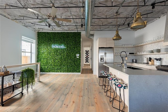 424 S Lopez St, New Orleans, LA 70119 - kitchen with stainless steel refrigerator with ice dispenser, a ceiling fan, light wood-type flooring, a kitchen bar, and open shelves