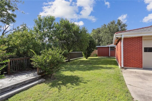 920 Hesper Ave, Metairie, LA 70005 - view of grassy yard featuring a garage, a wooden deck, and concrete driveway