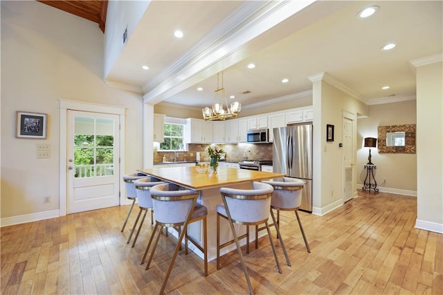 921 Carriage Way, Baton Rouge, LA 70808 - kitchen featuring stainless steel appliances, crown molding, a chandelier, light wood finished floors, and white cabinets