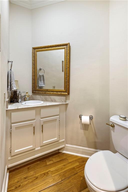 921 Carriage Way, Baton Rouge, LA 70808 - half bathroom with vanity, ornamental molding, and wood finished floors