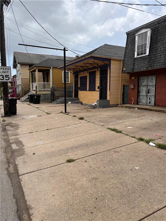 146062 N Claiborne Ave, New Orleans, LA 70116 - view of front of home featuring roof with shingles, a porch, brick siding, and mansard roof