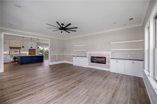 163 S 7th St, Ponchatoula, LA 70454 - unfurnished living room with ceiling fan, wood finished floors, a glass covered fireplace, and ornamental molding
