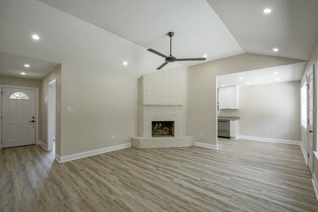 217 Chess Dr, Slidell, LA 70458 - unfurnished living room with vaulted ceiling, light wood finished floors, ceiling fan, recessed lighting, and a brick fireplace