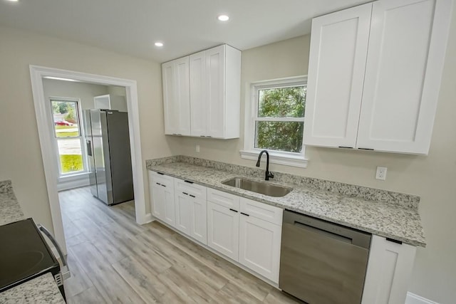 217 Chess Dr, Slidell, LA 70458 - kitchen with appliances with stainless steel finishes, white cabinets, light wood-type flooring, recessed lighting, and light stone counters