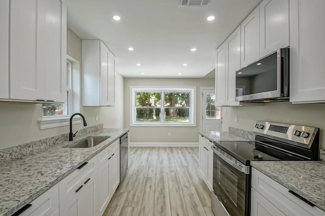 217 Chess Dr, Slidell, LA 70458 - kitchen with stainless steel appliances, light wood-style flooring, white cabinets, and recessed lighting