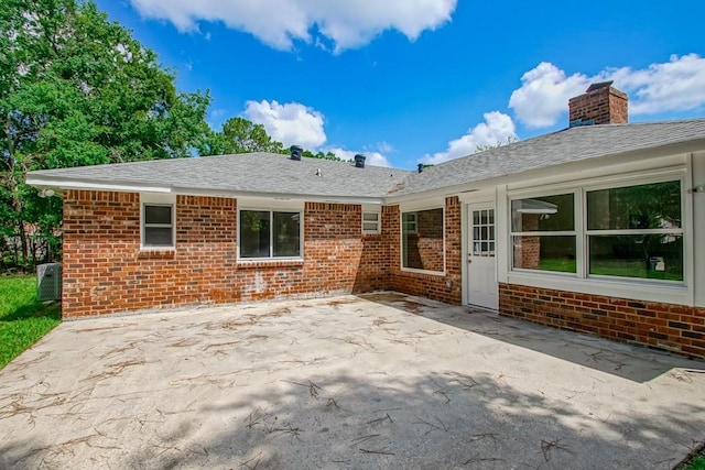 217 Chess Dr, Slidell, LA 70458 - rear view of house featuring brick siding, a patio area, a chimney, and a shingled roof