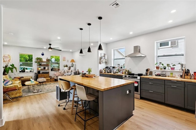 162224 N Dupre St, New Orleans, LA 70119 - kitchen with wood counters, wall chimney exhaust hood, stainless steel electric range oven, a breakfast bar area, and open floor plan