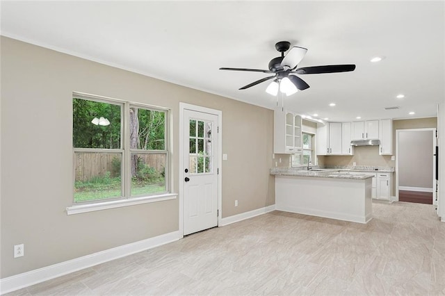 11 Karen Dr, Covington, LA 70433 - kitchen with under cabinet range hood, white cabinetry, plenty of natural light, a ceiling fan, and recessed lighting