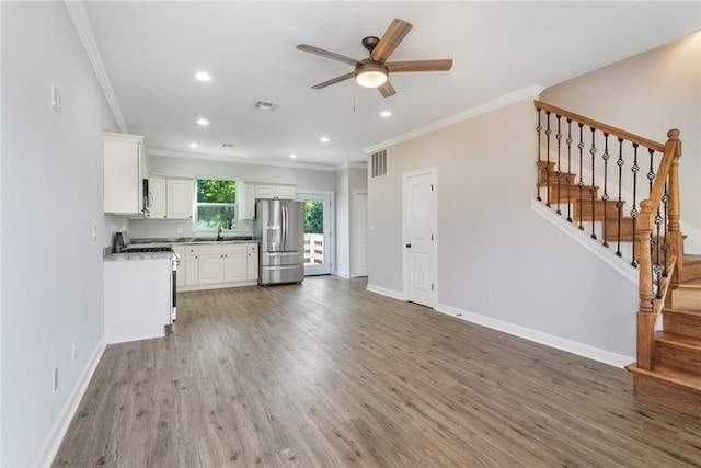 2626 N Dorgenois St, New Orleans, LA 70117 - unfurnished living room with ornamental molding, a ceiling fan, light wood-type flooring, recessed lighting, and stairs