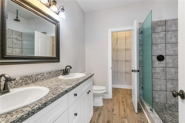 2626 N Dorgenois St, New Orleans, LA 70117 - bathroom with tiled shower, wood finished floors, double vanity, and a walk in closet