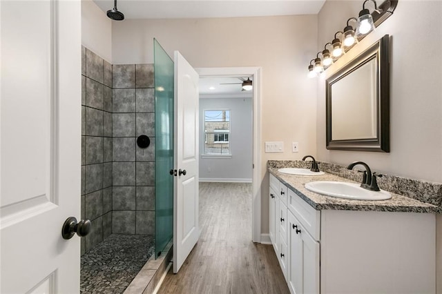 2626 N Dorgenois St, New Orleans, LA 70117 - full bathroom with wood finished floors, double vanity, and a tile shower
