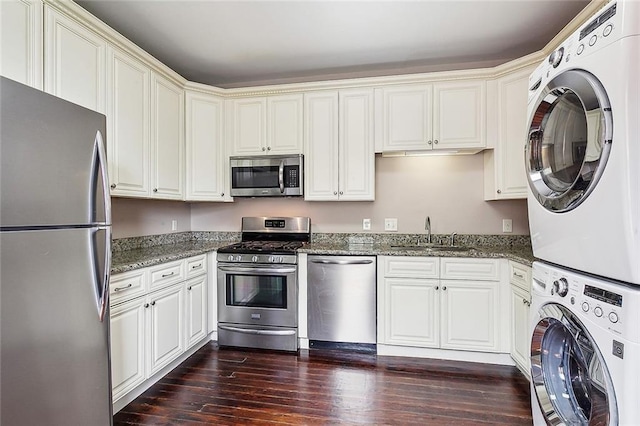 2907-09 Paris Ave, New Orleans, LA 70119 - kitchen with stainless steel appliances, estacked washer and dryer, stone counters, and dark wood-style flooring
