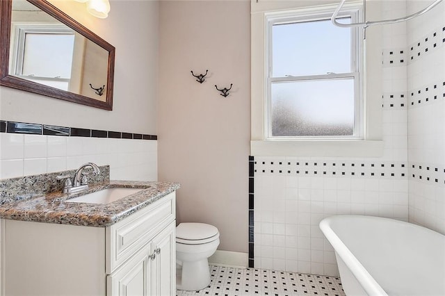2907-09 Paris Ave, New Orleans, LA 70119 - full bathroom featuring tile walls, a freestanding bath, vanity, healthy amount of natural light, and wainscoting