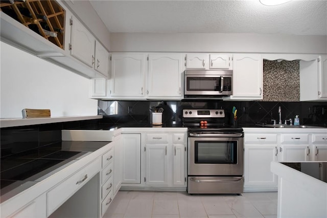 109 Topsl Dr Unit 109, Mandeville, LA 70448 - kitchen with appliances with stainless steel finishes, white cabinets, and decorative backsplash