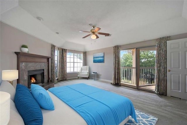 109 Topsl Dr Unit 109, Mandeville, LA 70448 - bedroom with access to exterior, a premium fireplace, a ceiling fan, and a tray ceiling