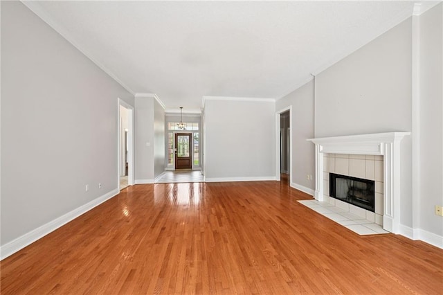 544 Waverly Dr, Slidell, LA 70461 - unfurnished living room featuring light wood-style floors, a chandelier, a fireplace, and crown molding