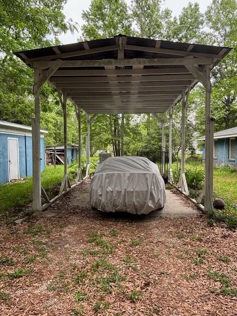 19343 9th Ave, Covington, LA 70433 - view of parking featuring a detached carport and a storage unit
